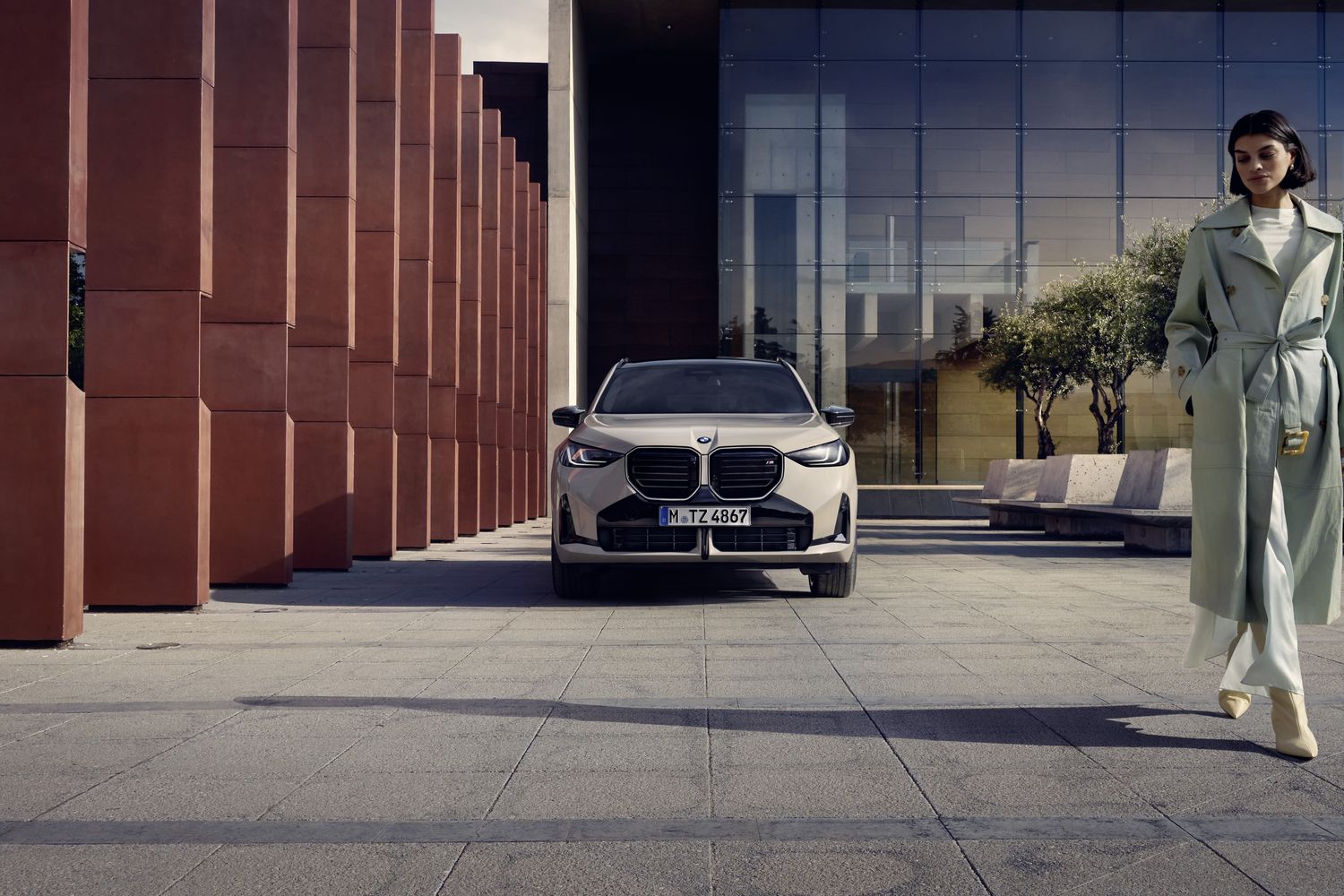 Exterior of the new BMW X3 parked at home, with driver walking past car.