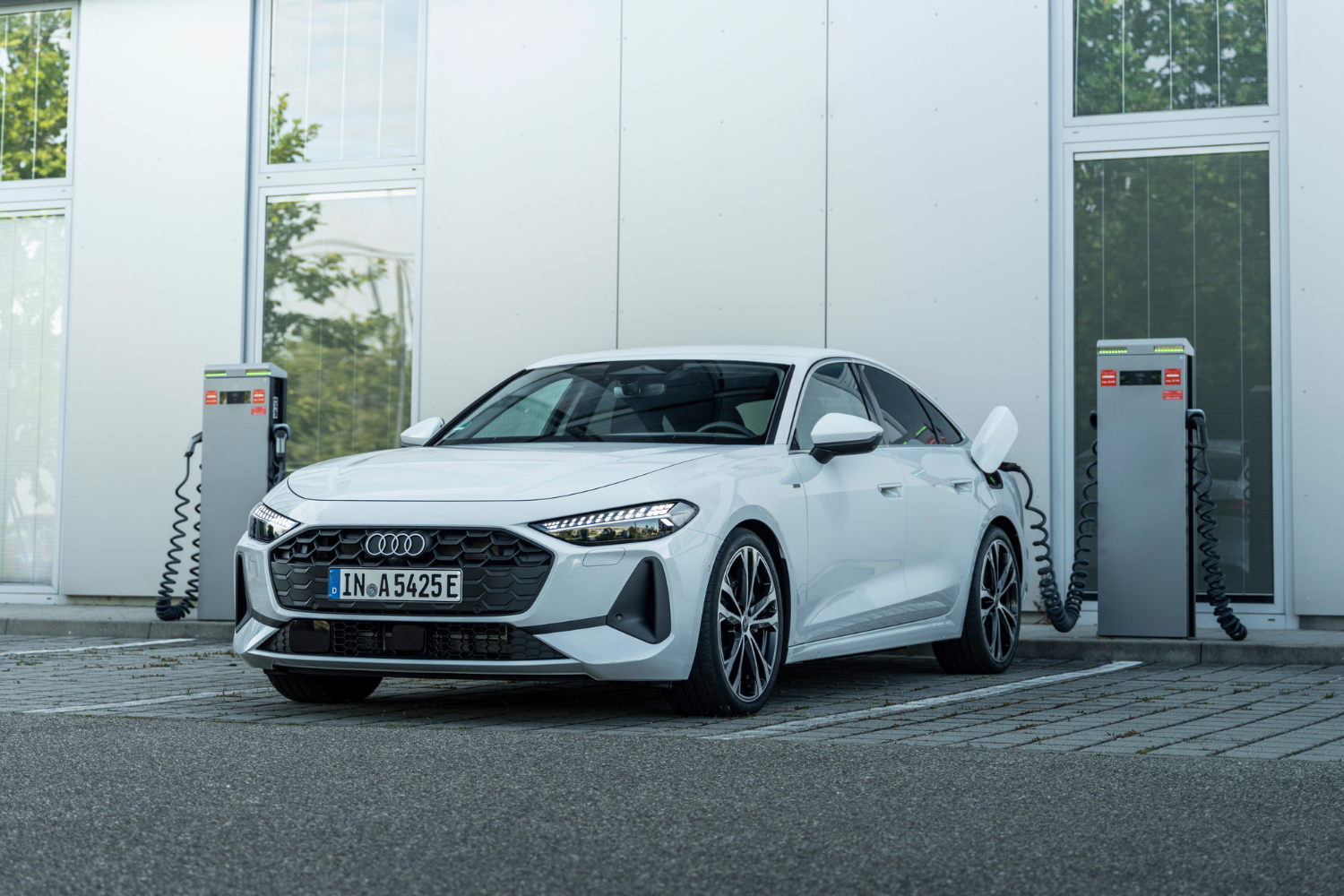 2025 Audi A5 Saloon e-hybrid in Glacier White charging at a charging port.