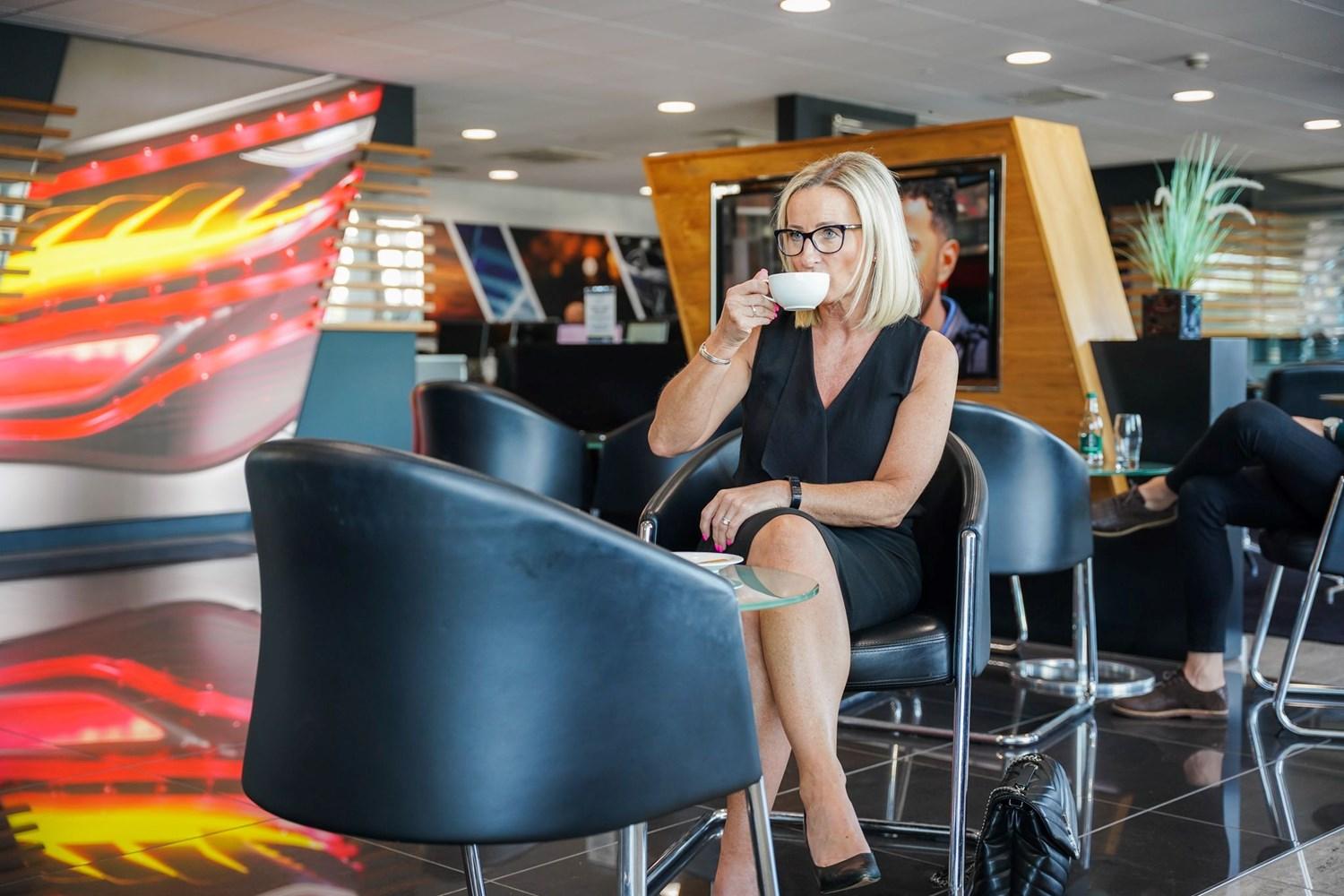 Mercedes-Benz customer enjoys a cup of coffee while they wait at the Mercedes-Benz of Belfast showroom