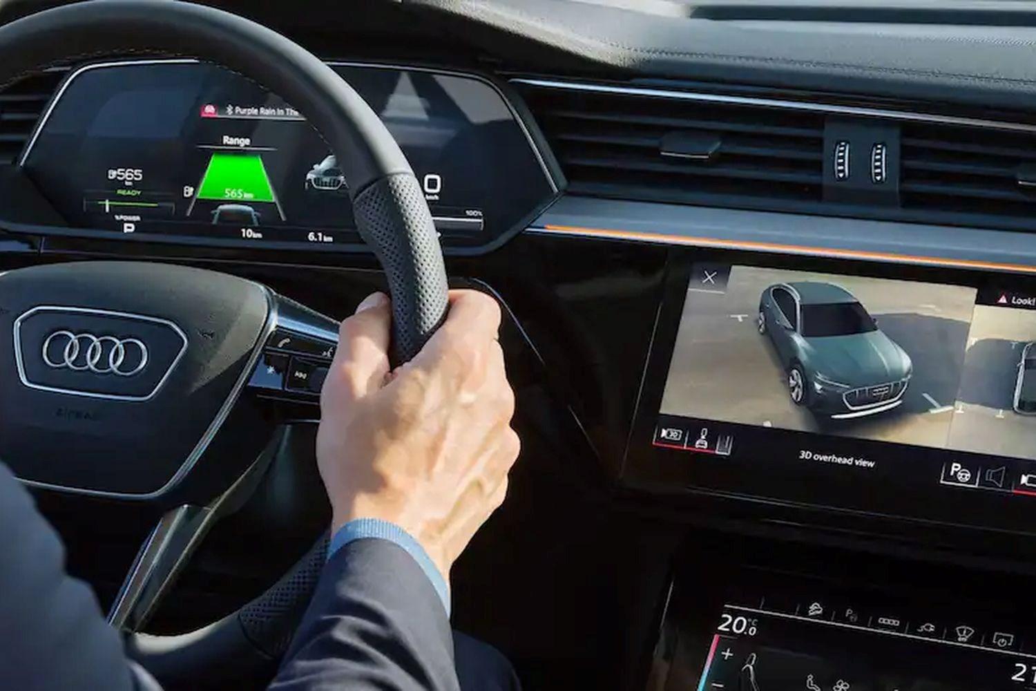 Close-up of customer driving an Audi vehicle with the infotainment system in view