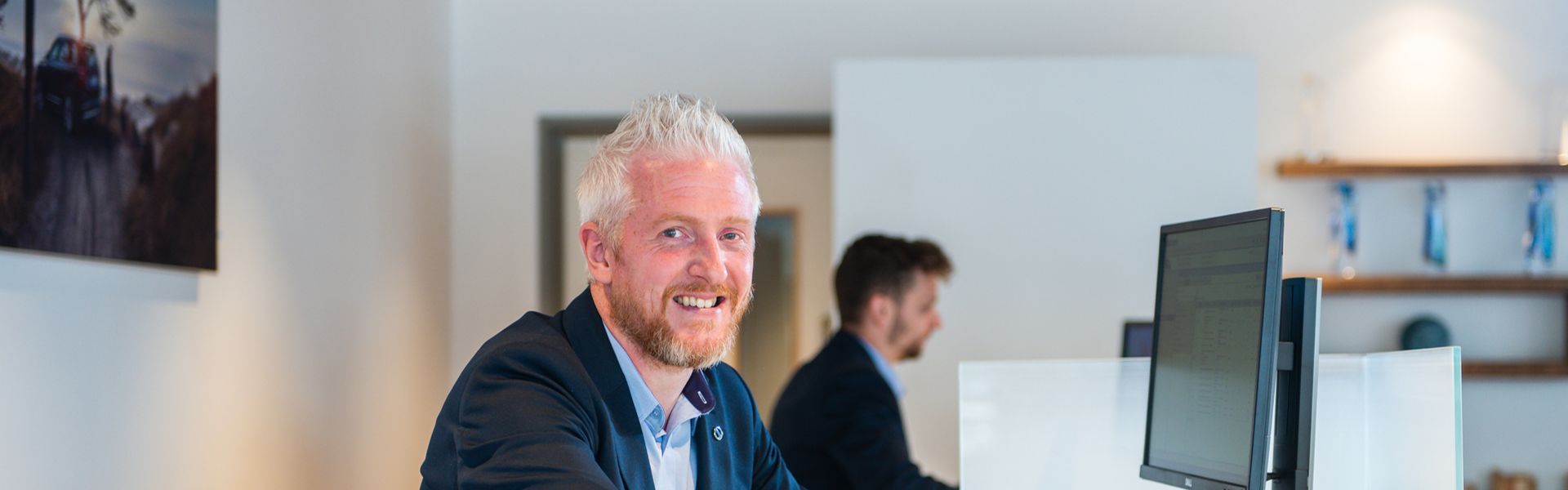Agnew Belfast Volvo sales team member smiles while using desktop computer