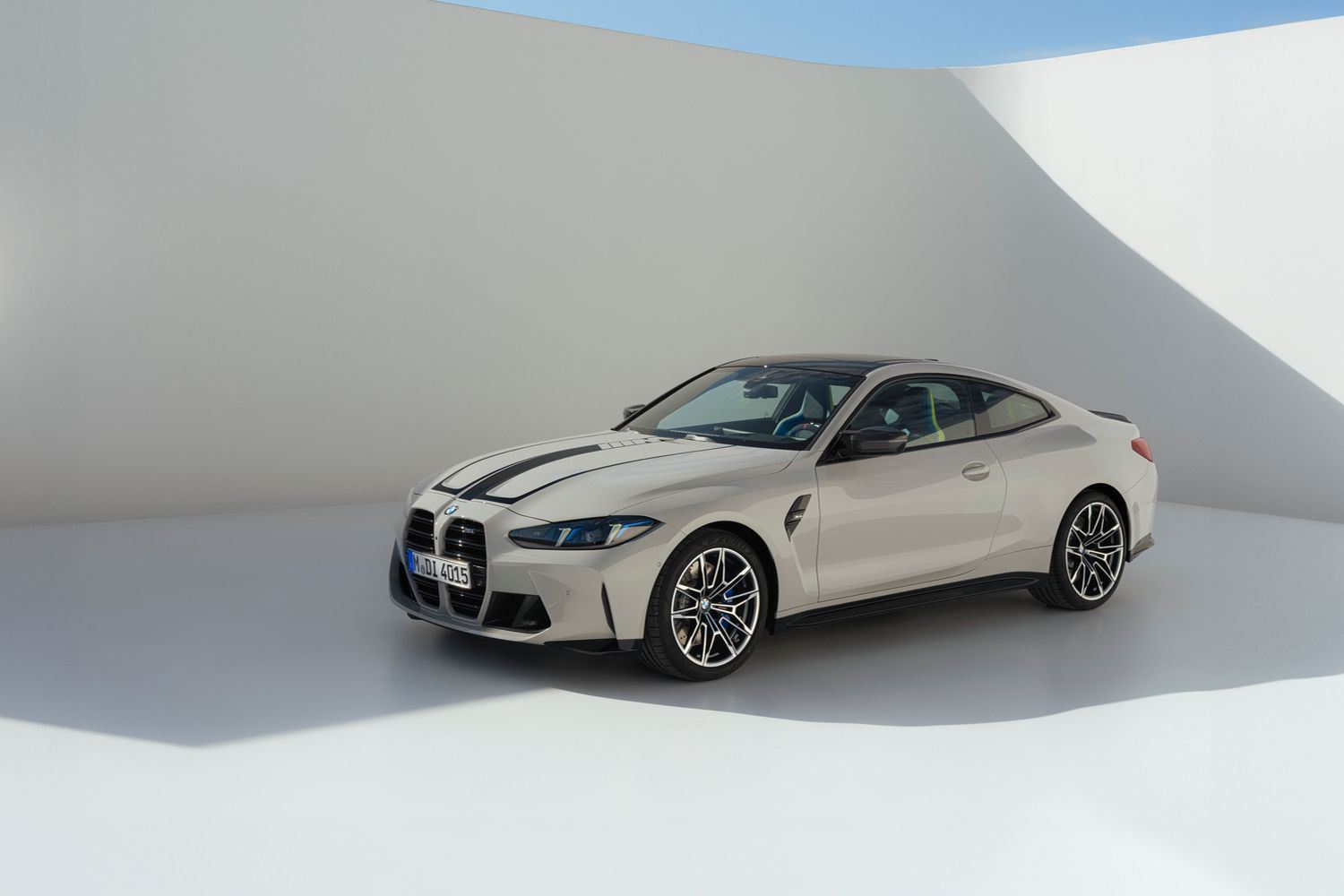 Side view of the BMW M4 Competition Coupe, in white with black detailing, on neutral background