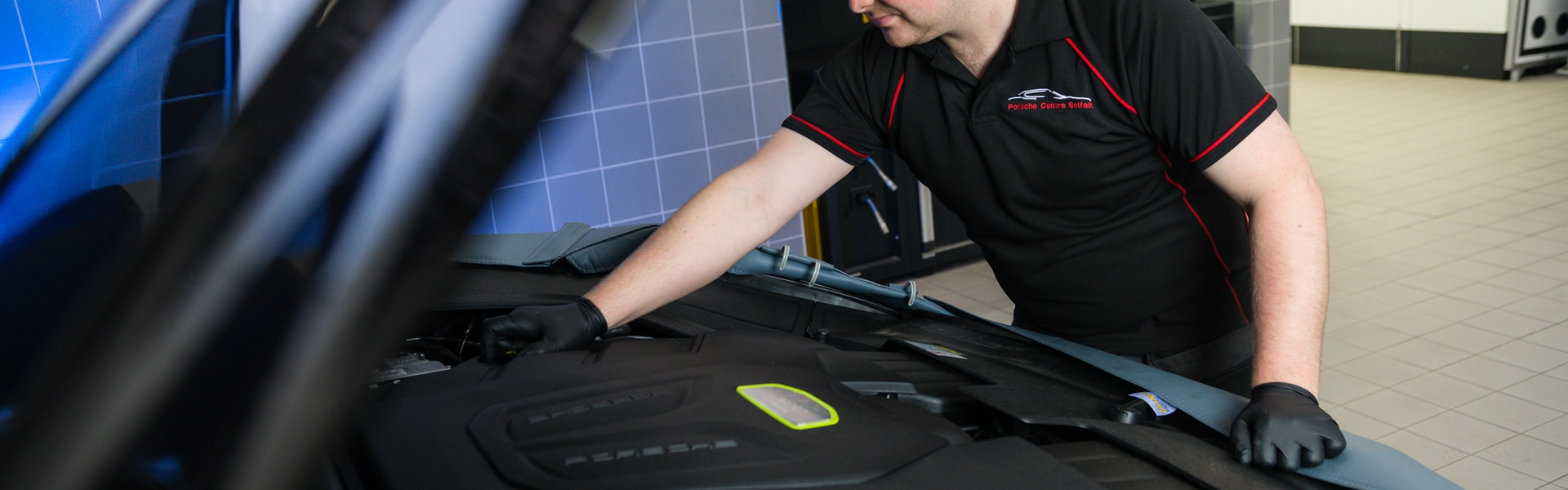 Porsche Repair Centre Repair Specialist inspects under the hood of a Porsche vehicle for any repairs needed at the Porsche Approved Repair Centre at Porsche Centre Belfast