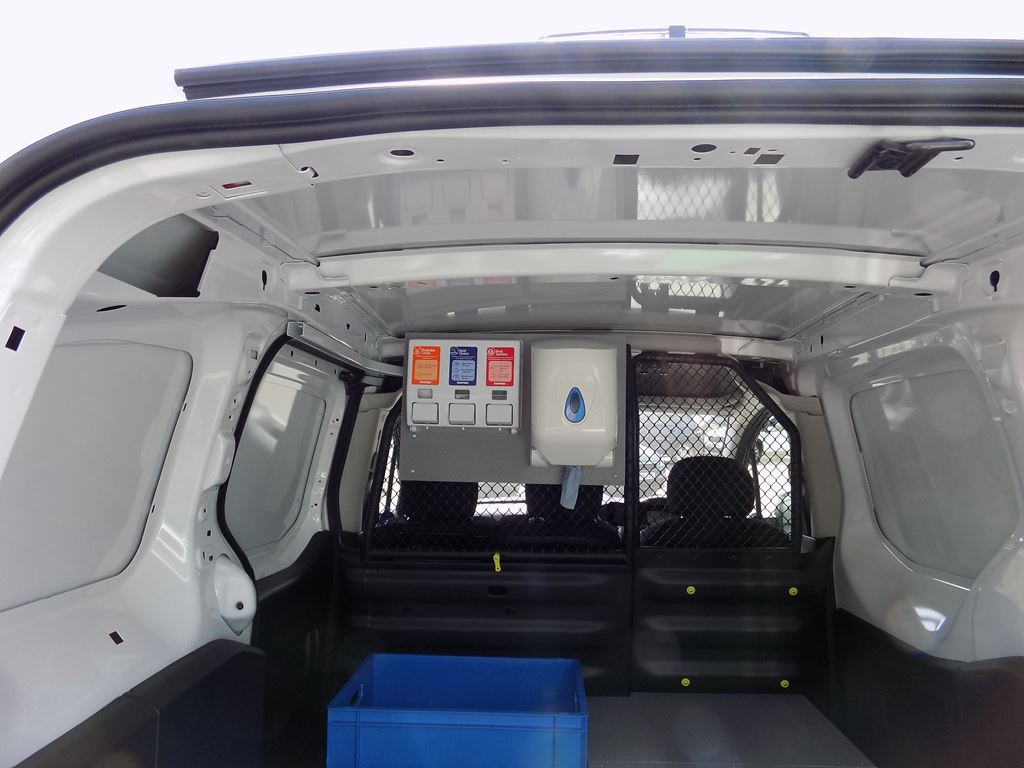Van cargo area with protective bulkhead and wall-mounted dispenser unit.