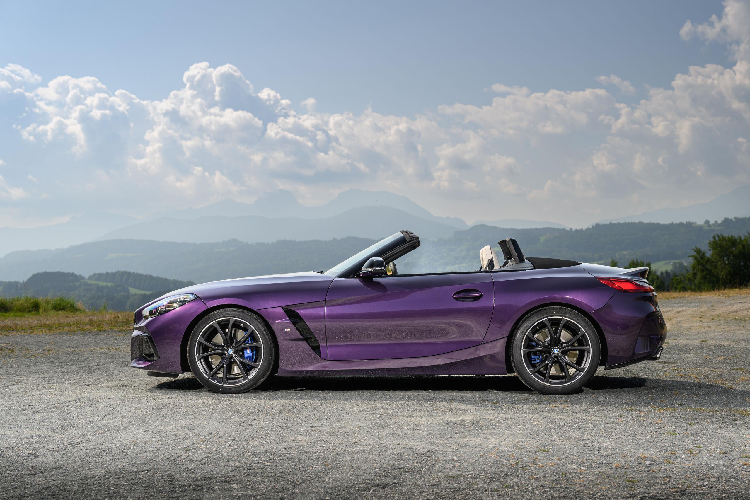 Side view of new BMW Z4, in purple, parked in countryside