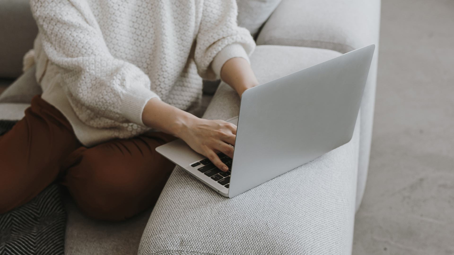 Person sitting on a sofa with laptop
