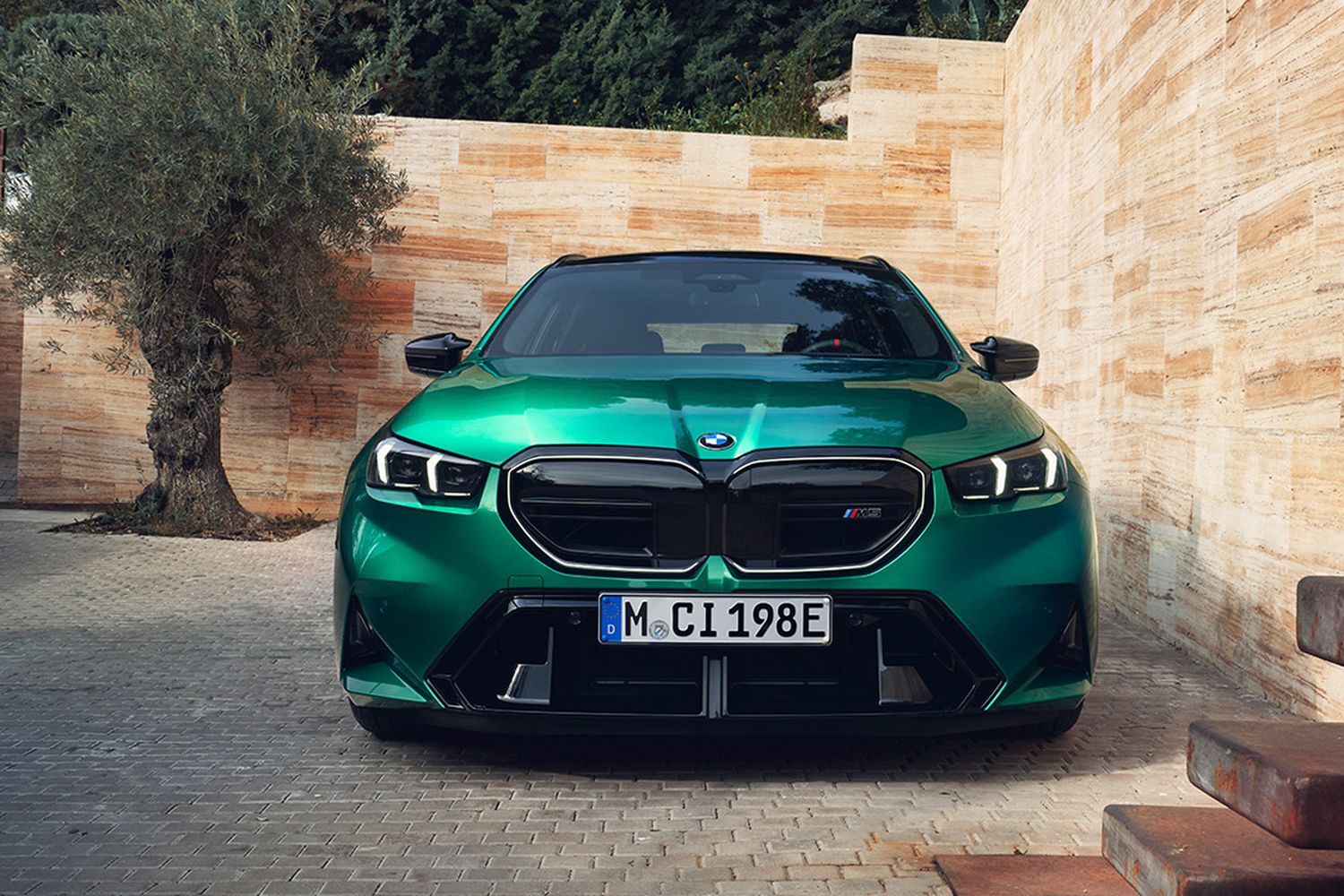 Front view of the new BMW M5 Touring. Parked in private garden.