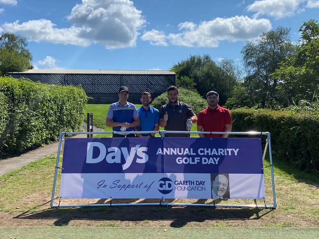 4 Men stood in front of Day's Annual Charity Golf Day banner