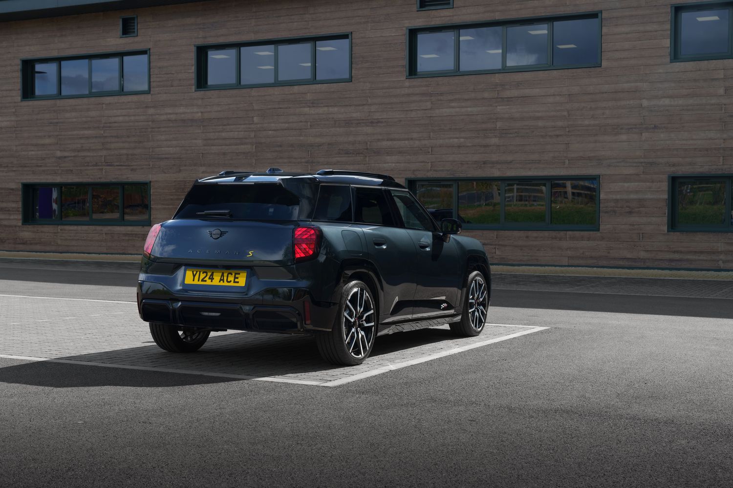 The new all-electric MINI Aceman in black, parked in car park.