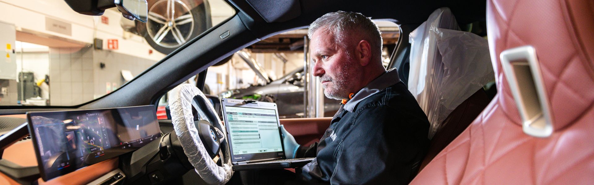BMW Technician inspects the inside of BMW vehicle and tests the cameras during routine maintenance at Bavarian BMW Belfast