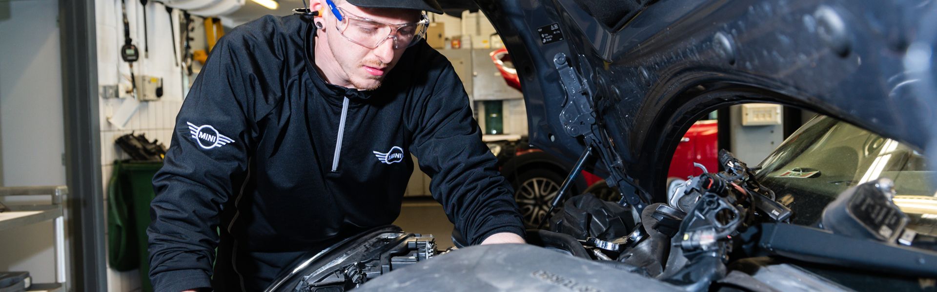 Bavarian MINI Repair Specialist inspects under the hood of a MINI Countryman at the MINI Repair Centre and Bavarian MINI