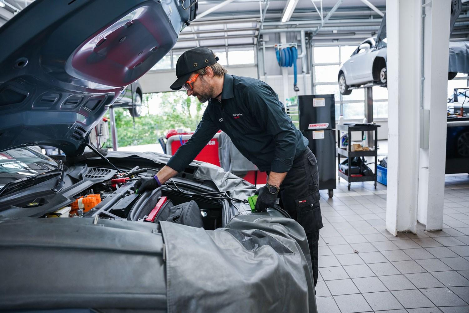 Audi Repair Specialist inspects under the hood of an Audi A5 during routine maintenance at Portadown Audi