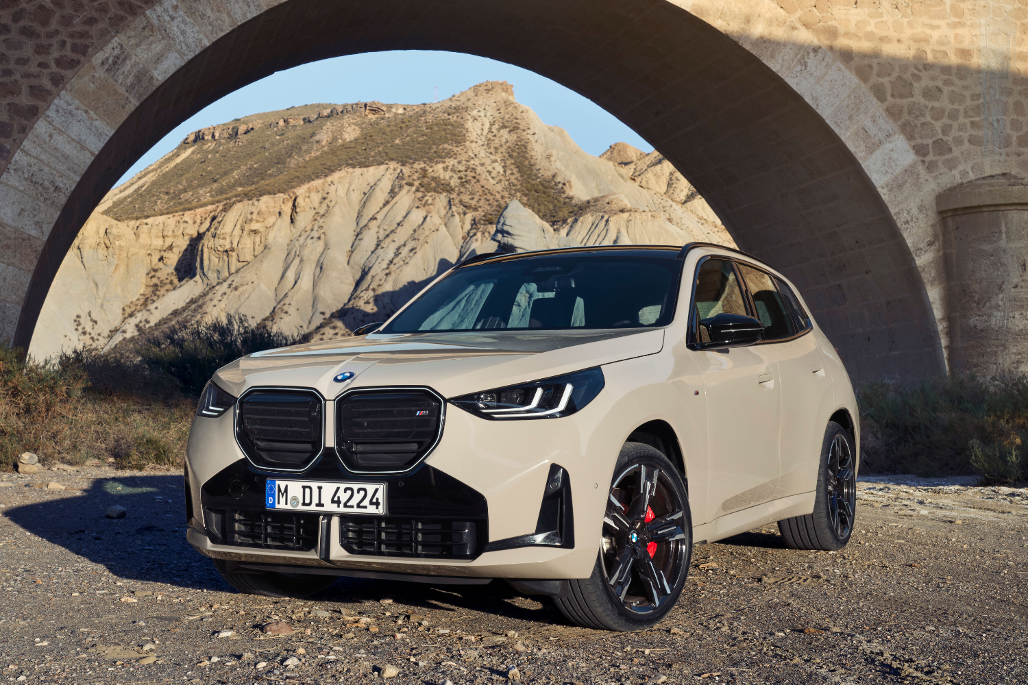 Close-up of the latest BMW X3 parked under a stone bridge