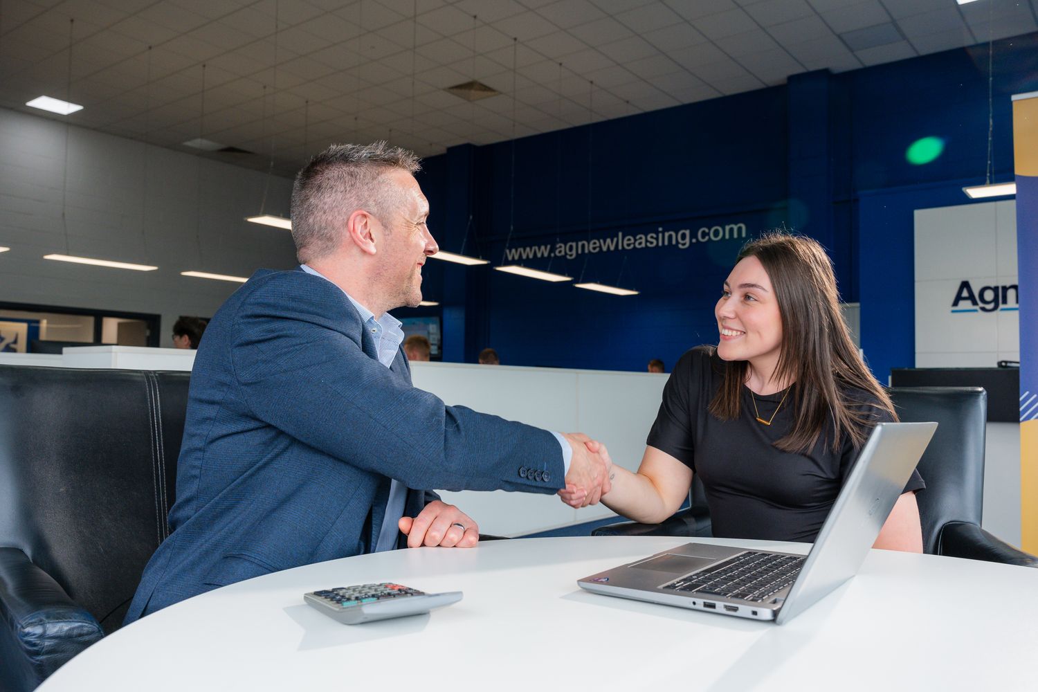 Customer shakes hand of Agnew Leasing specialist after discussing vehicle rental
