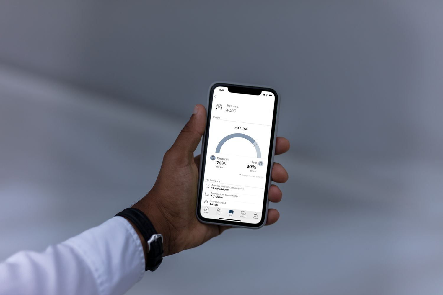 Volvo customer holds phone with Volvo Cars App displaying information about the customers Volvo XC90