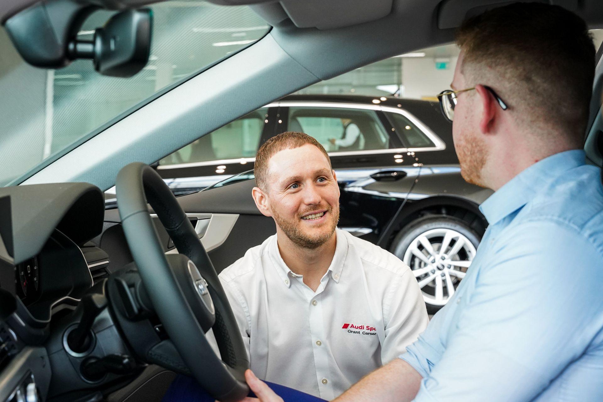 Audi Sales person speaks to customer about the Audi Approved Used Programme in car