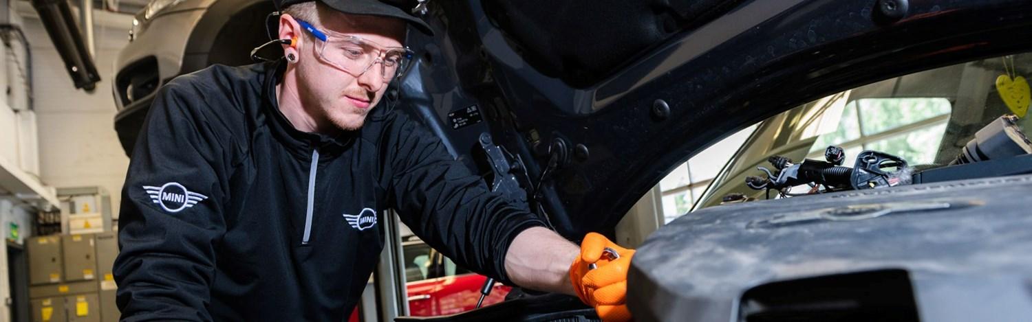 MINI Repair Specialist inspects engine of a MINI for repairs at the MINI Repair Centre at Bavarian MINI