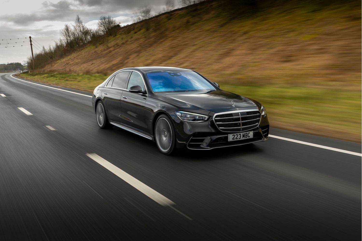 A side view of a black Mercedes-Benz S-Class Saloon driving.