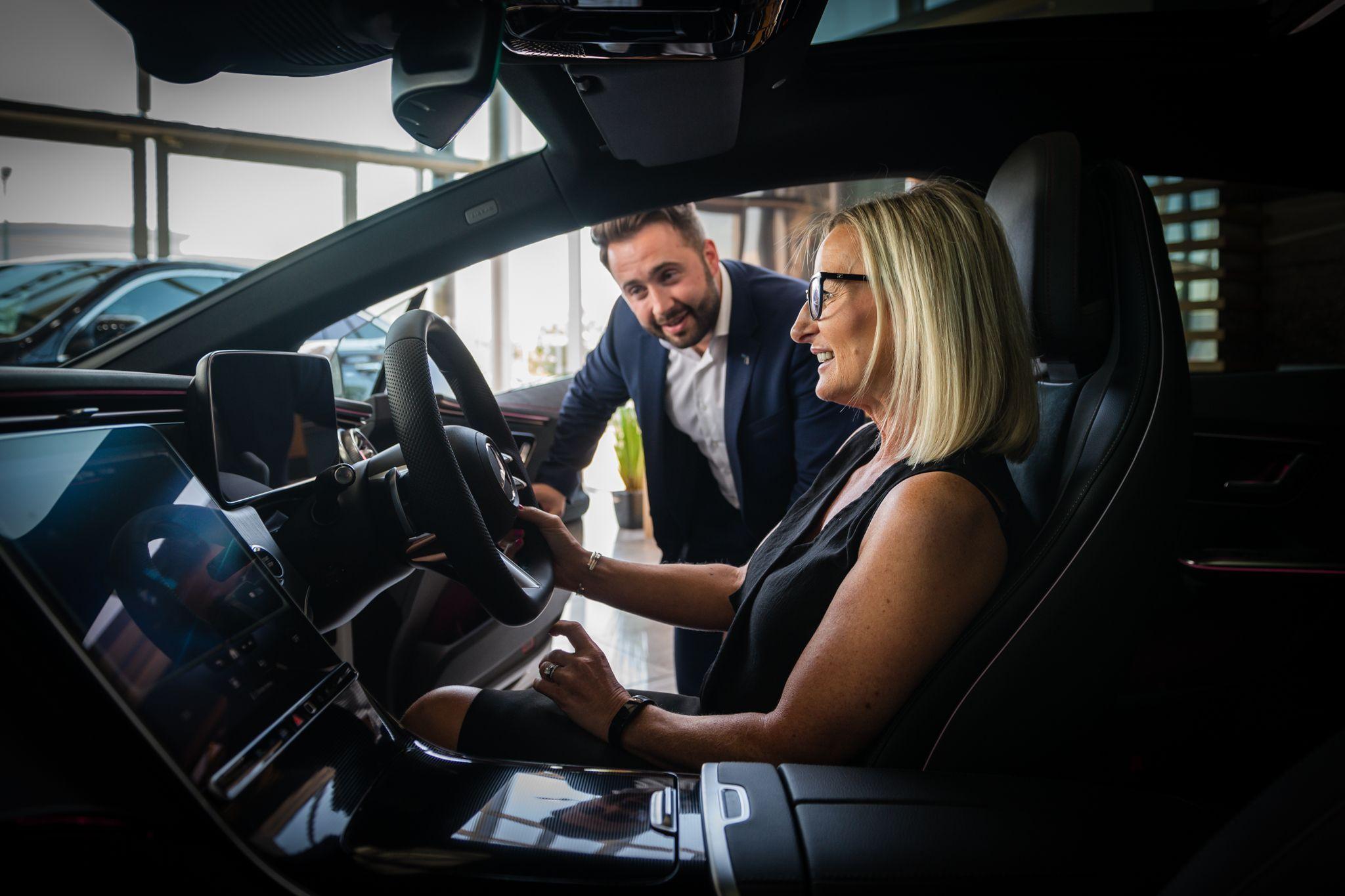 Mercedes-Benz Used Sales Team Member chats to customer inside the vehicle about the benefits of the MB Select programme