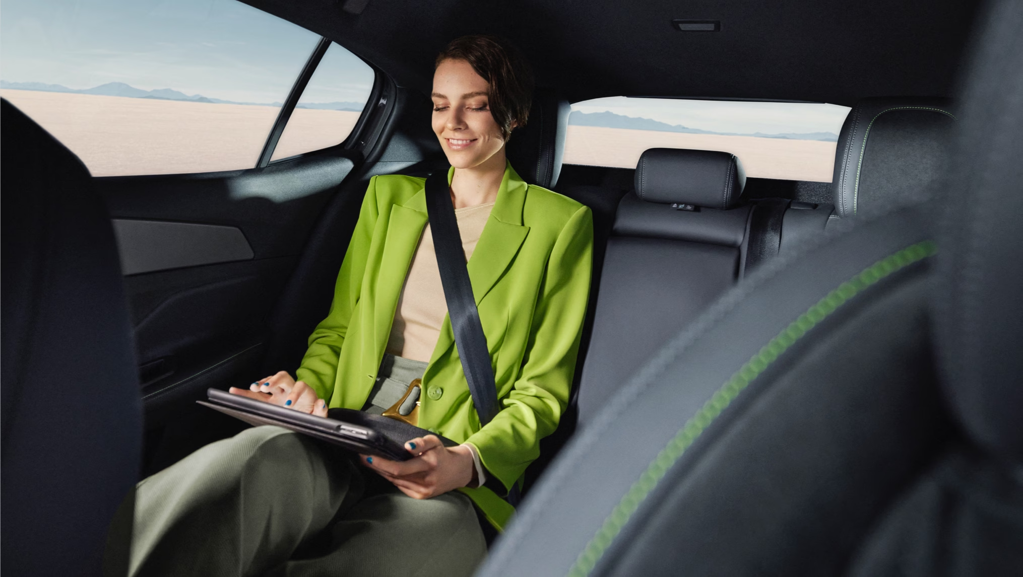 Woman sat in back of Peugeot 408 on a tablet