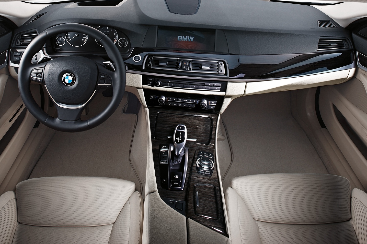 Interior view of a BMW vehicle with close-up on steering wheel, dashboard and infotainment system
