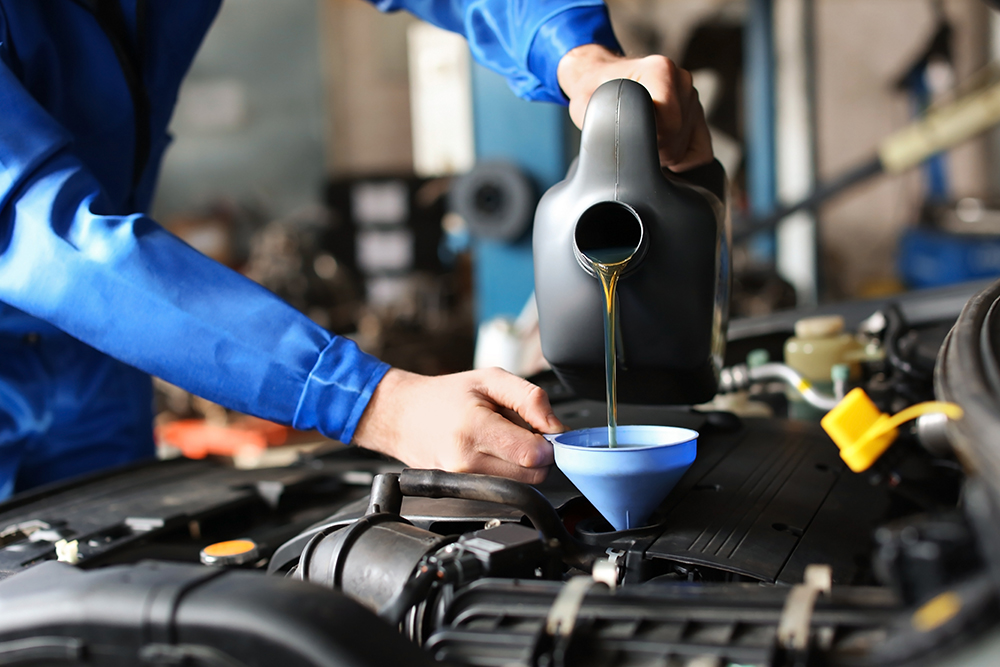 BMW Technician pours new brake fluid during brake fluid change at Bavarian BMW Belfast