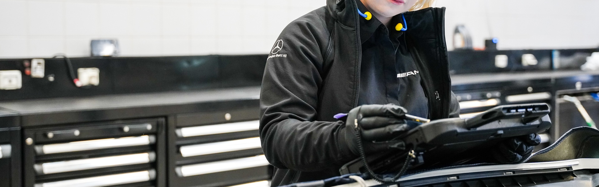 Mercedes-Benz Technician inspects the electrics of a Mercedes-Benz vehicle on tablet during MOT inspection