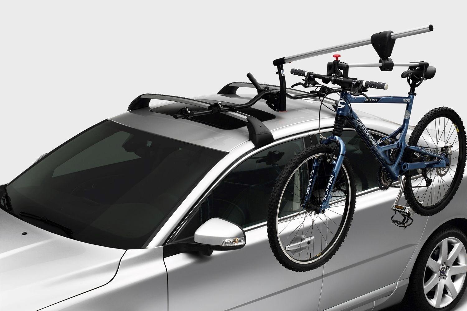 The latest Volvo XC60 with a roof rack installed holds an blue adult bicycle