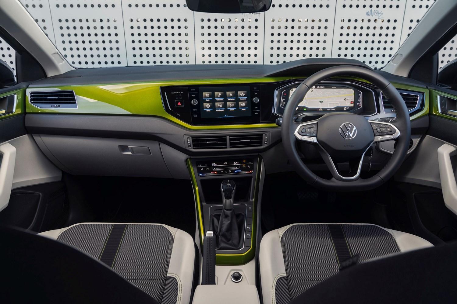 Interior view of the new Volkswagen Taigo in green, close-up on the front passenger seats, central infotainment system and steering wheel