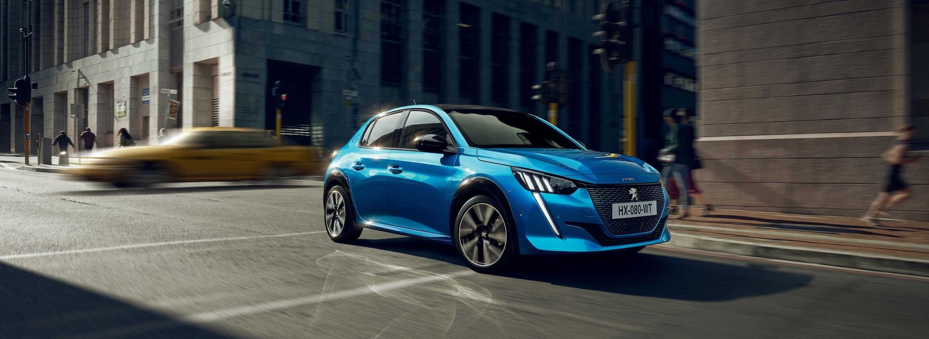Blue Peugeot 208 driving along street
