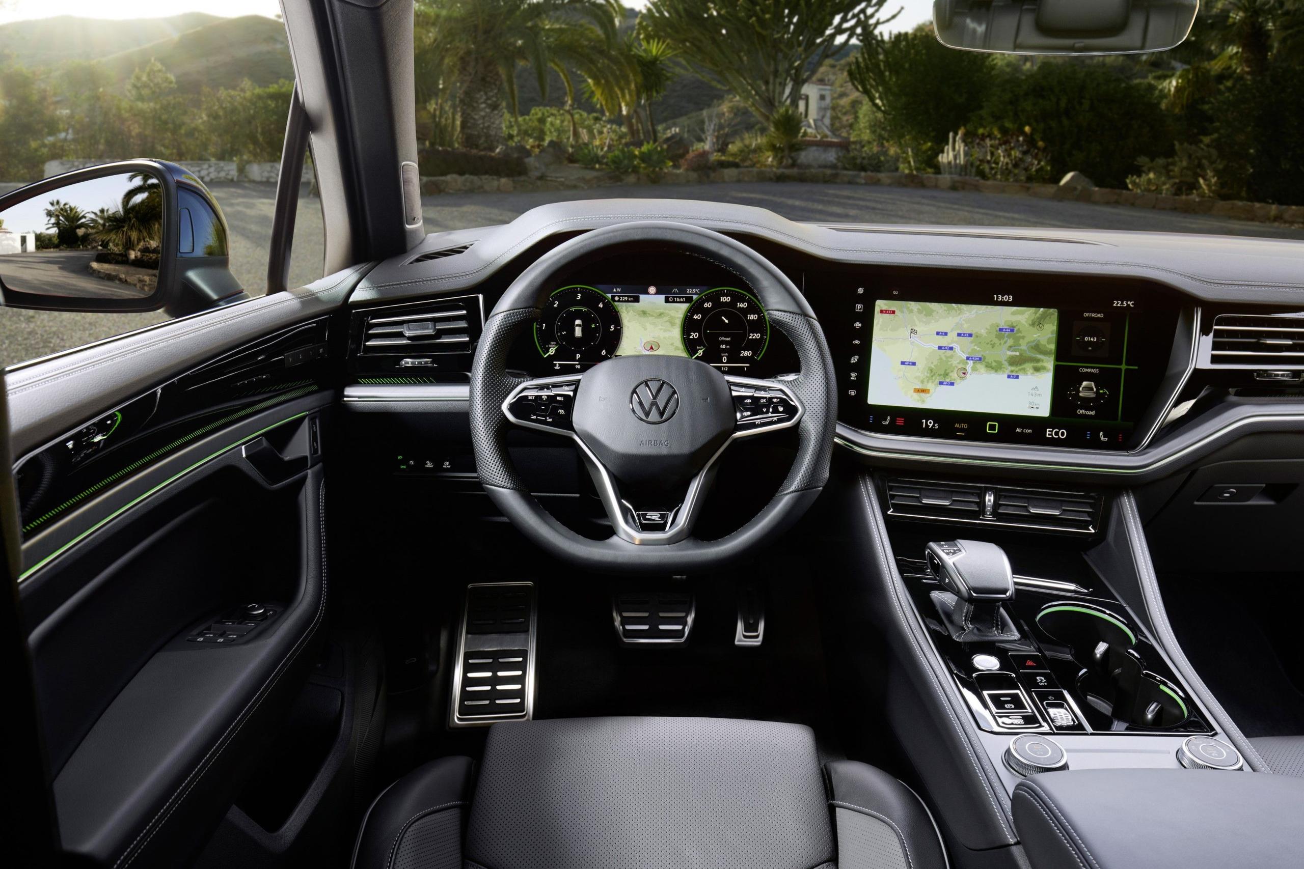 Interior view of the new Volkswagen Touareg in red, with a focus on the steering wheel and central infotainment system