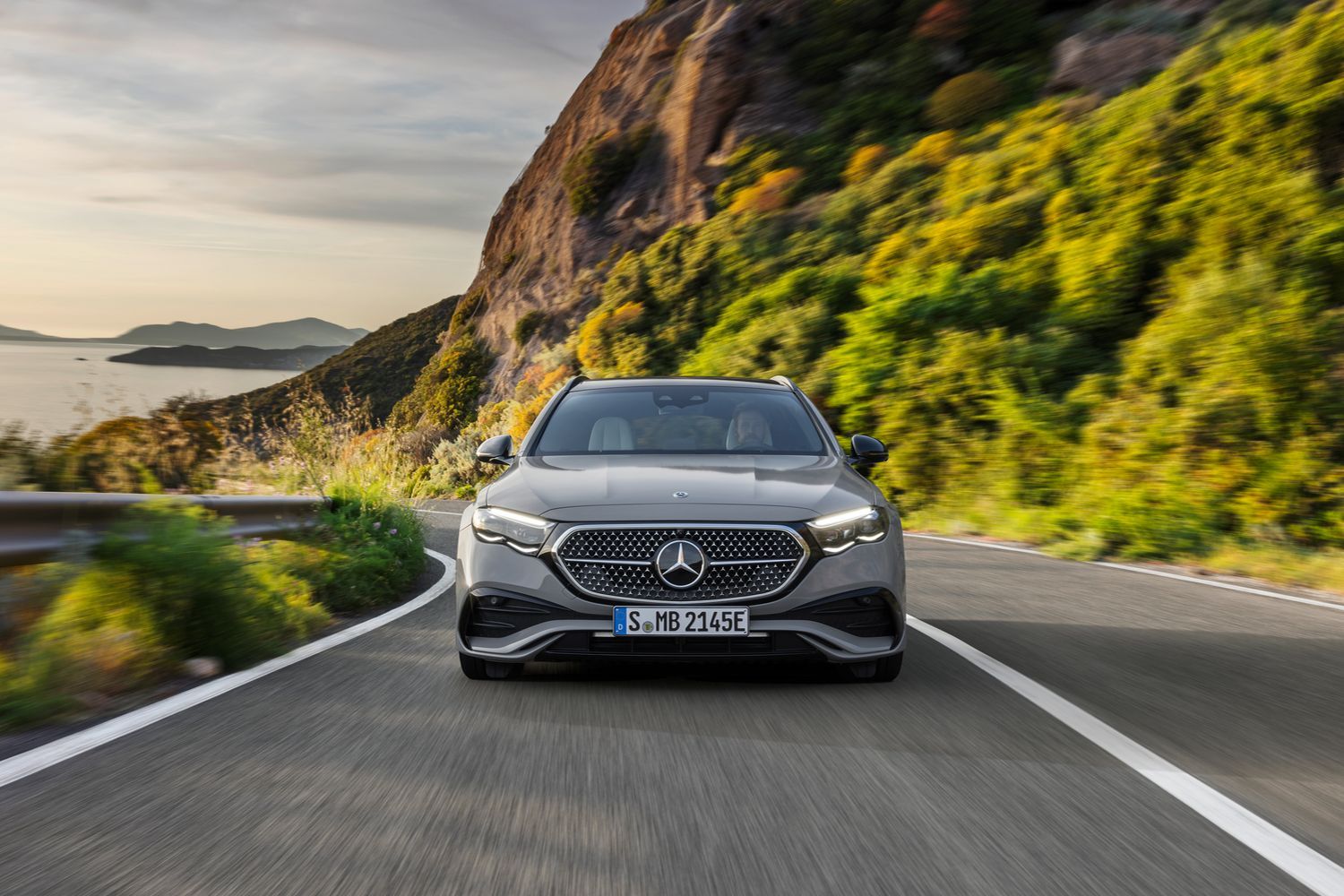 The front of a silver Mercedes-Benz E-Class Estate driving.