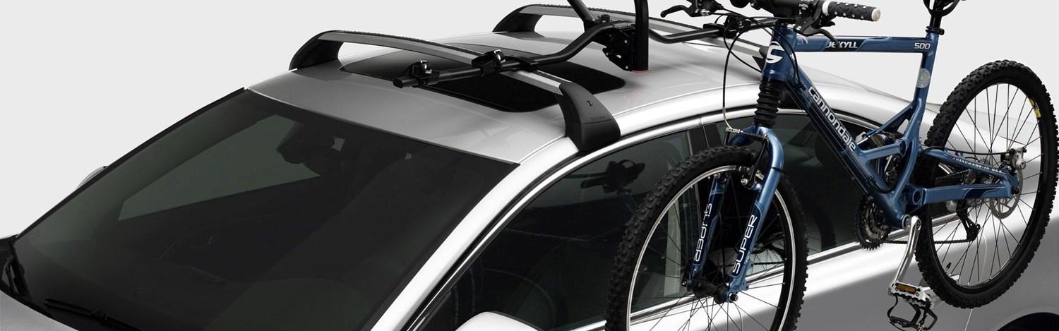 The latest Volvo XC60 car with a roof rack installed holds a blue adult bicycle