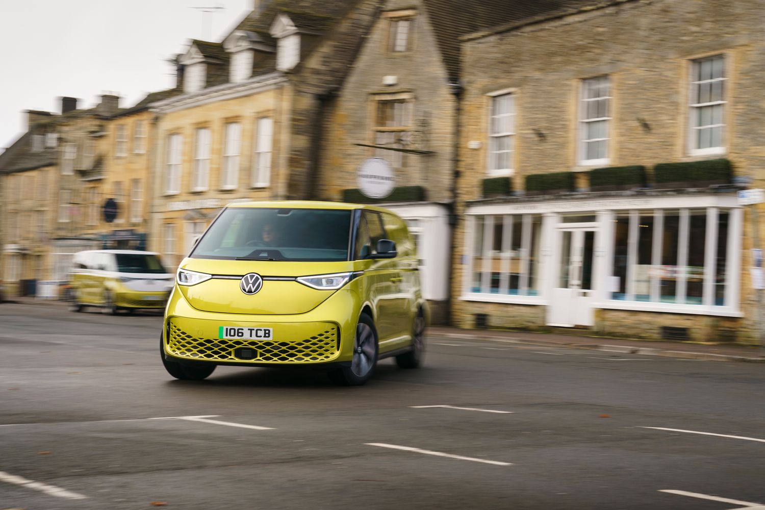 The new Volkswagen ID.Buzz Cargo, driving around a town making deliveries.